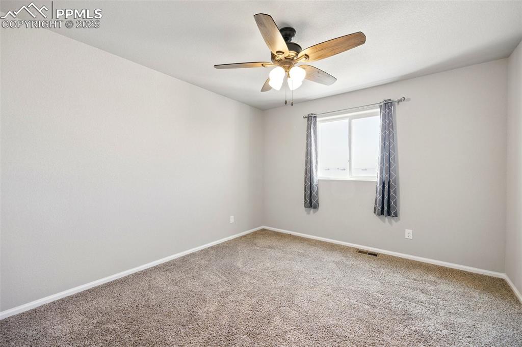 Image 22 of 46: Carpeted spare room with baseboards and a ceiling fan
