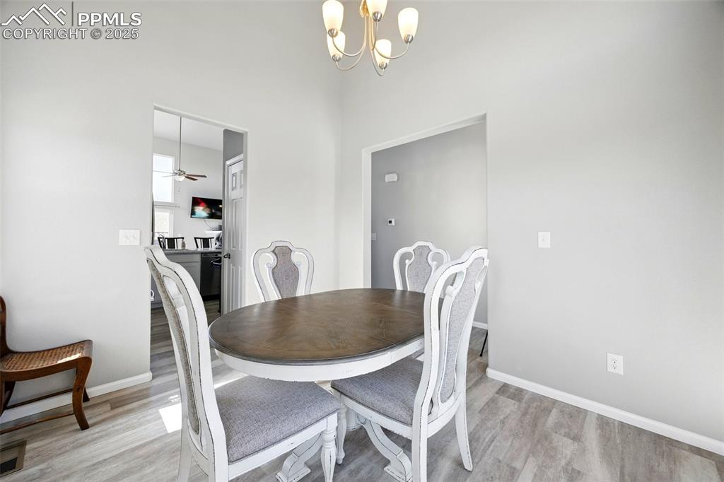 Image 25 of 46: Dining room with a chandelier, light wood-style flooring, and ceiling fan