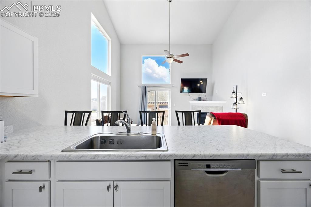 Image 3 of 46: Kitchen with white cabinets, stainless steel dishwasher, open floor plan, a