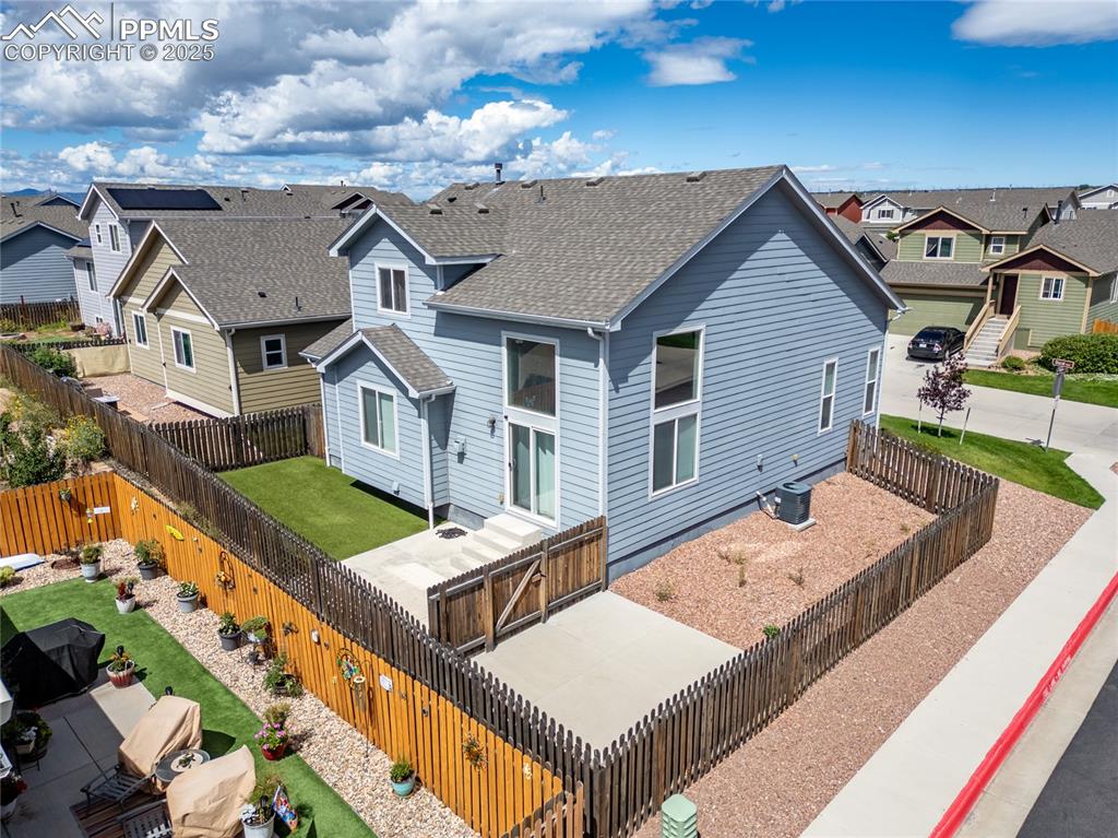 Image 41 of 46: Rear view of house featuring a residential view, a shingled roof, a fenced