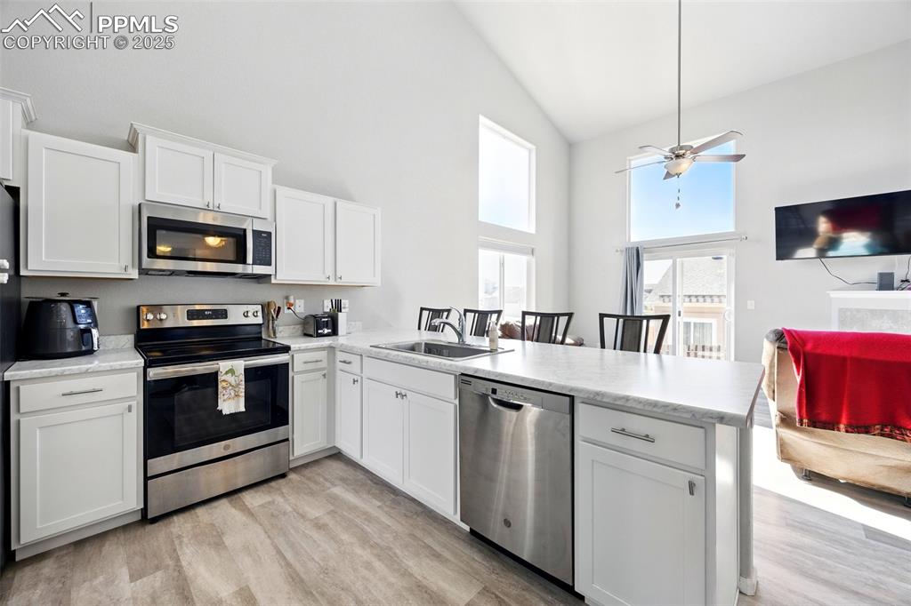 Image 5 of 46: Kitchen featuring stainless steel appliances, open floor plan, light counte