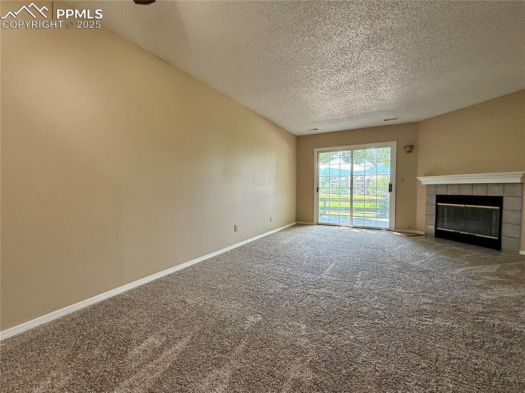 Image 3 of 23: Spacious living room with a fireplace and walk-out to the patio.