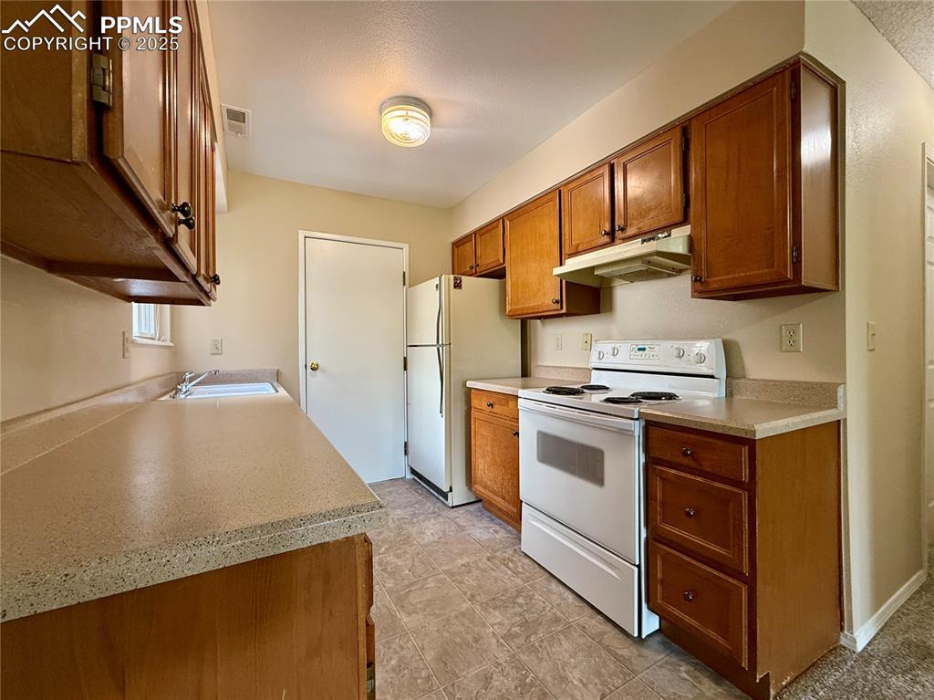 Image 6 of 23: Nice galley kitchen with a door to the garage.