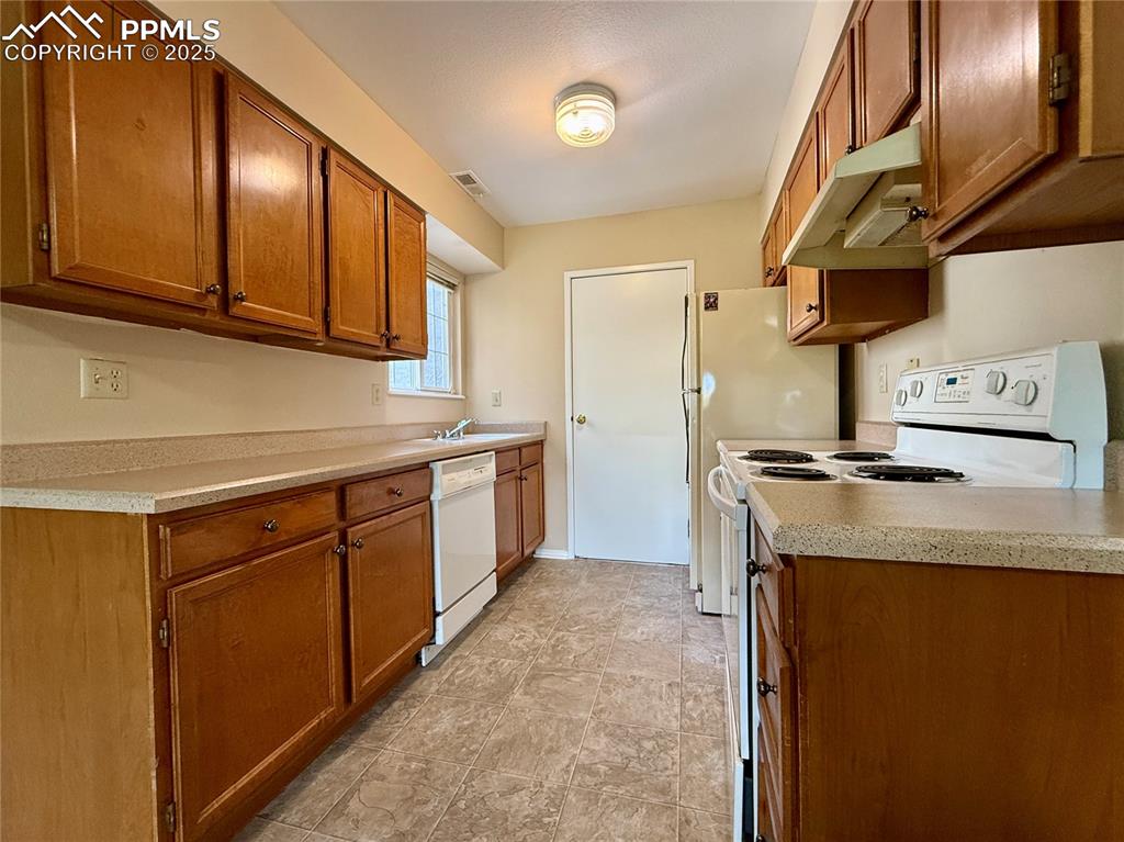 Image 7 of 23: Nice galley kitchen with a door to the garage.
