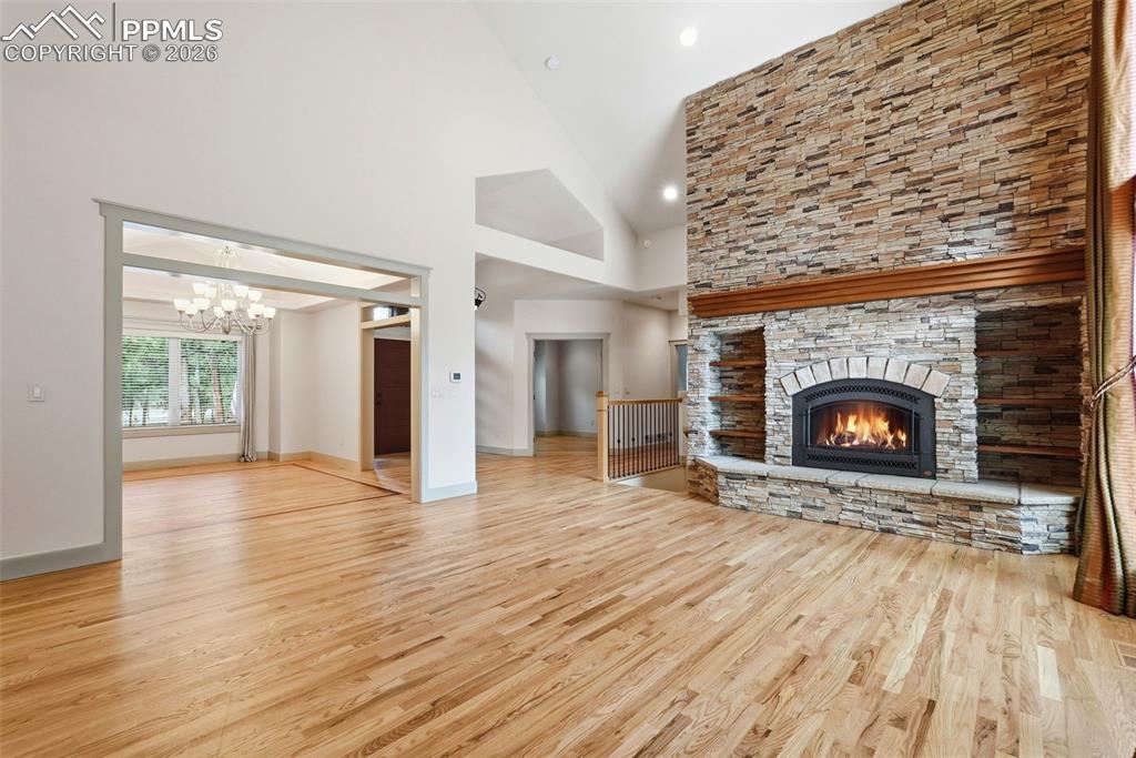 Image 15 of 50: Main level Family Room or Den with a stone fireplace, oak floors and wetbar