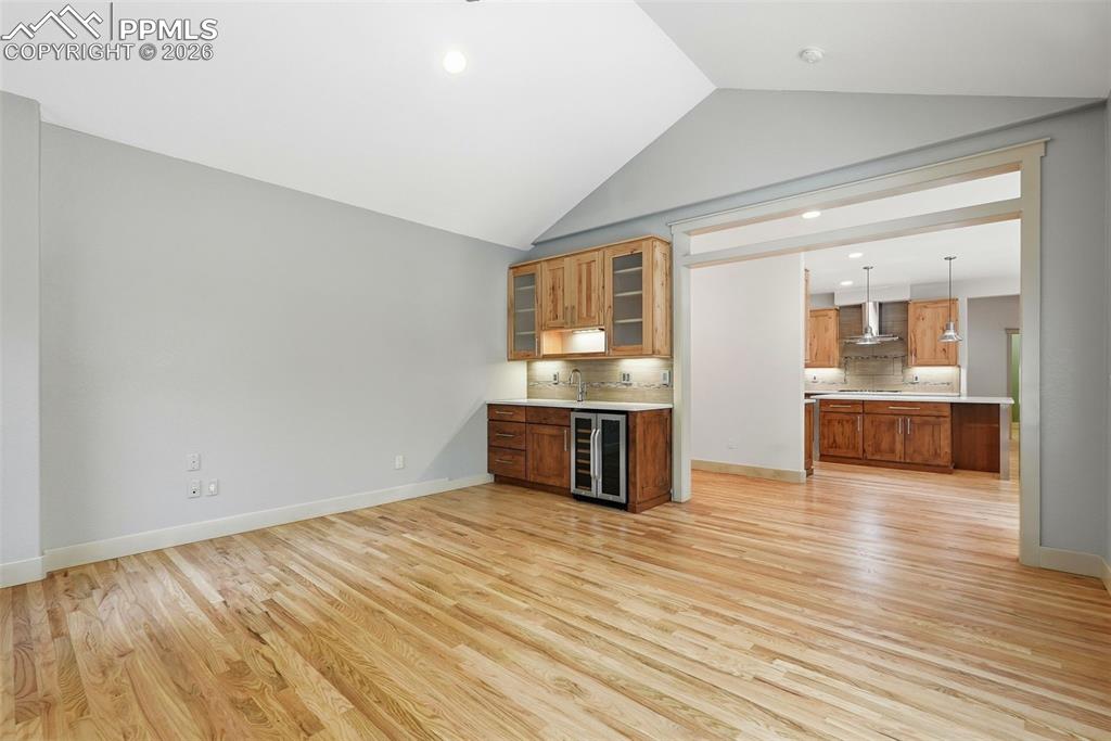 Image 16 of 50: Den/Family room features a fireplace and wet bar with glass cabinets and wi