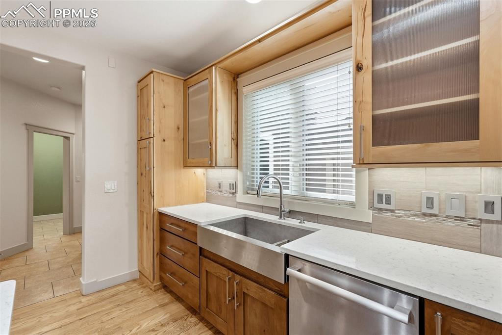 Image 23 of 50: Kitchen featuring glass insert cabinets, stainless steel apron sink , dishw