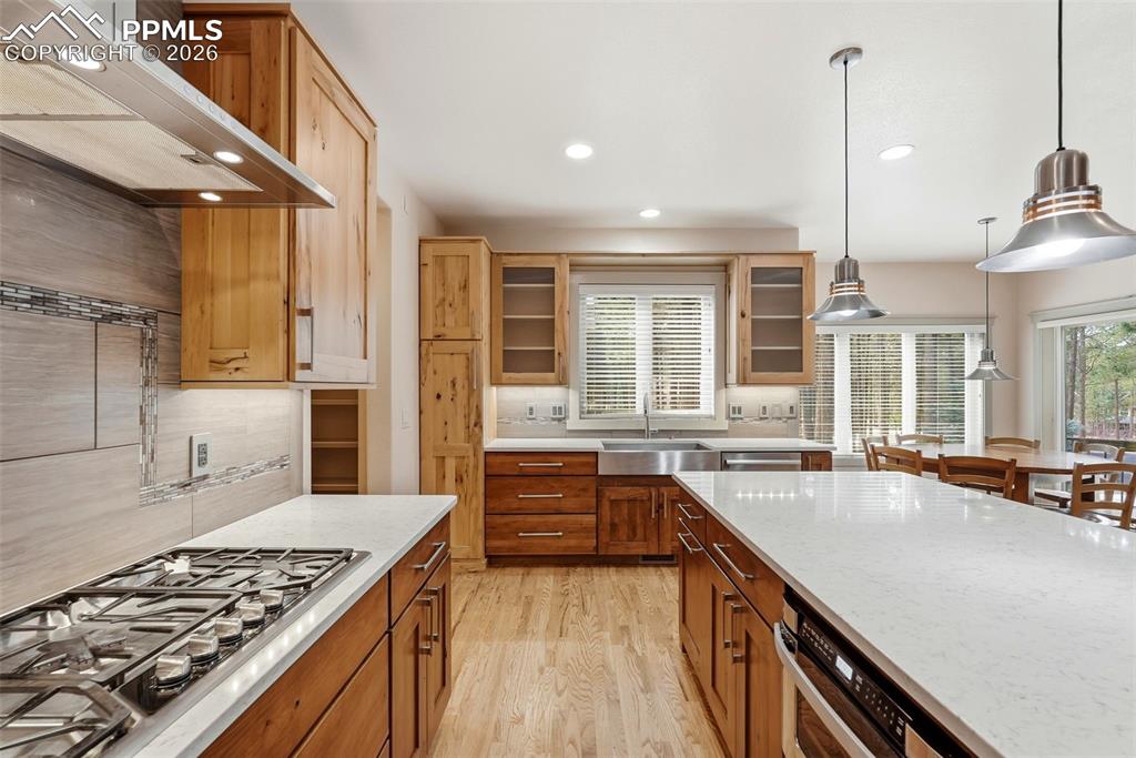 Image 25 of 50: Ga range, luxury stainless steel appliances,tasteful backsplash, and light 