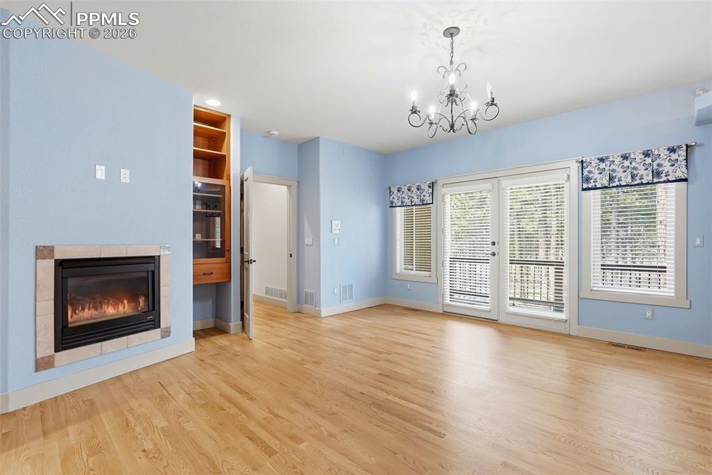 Image 31 of 50: Master Bedroom with chandelier oak floors and private balcony