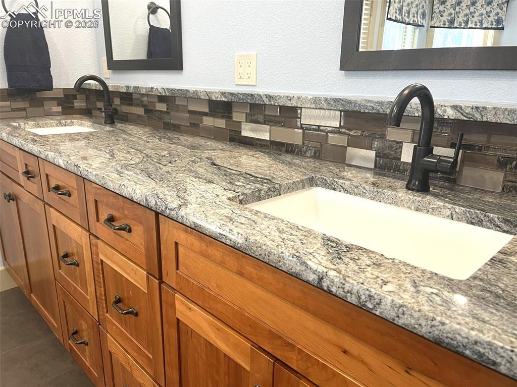 Image 34 of 50: Bathroom featuring double vanity and a textured wall