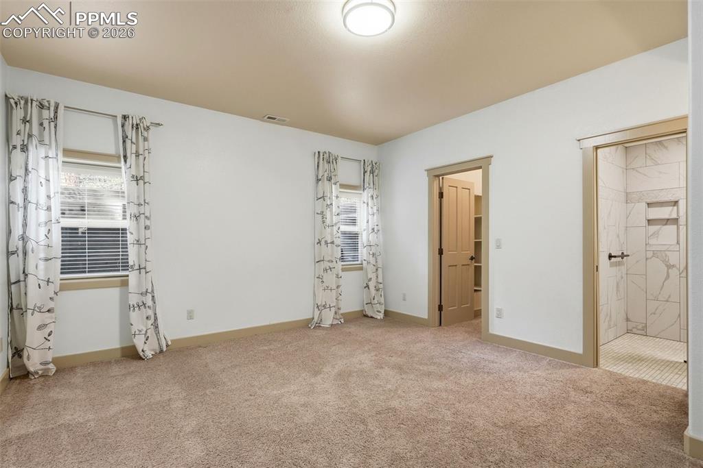 Image 41 of 50: 2nd bedroom with light colored carpet and baseboards