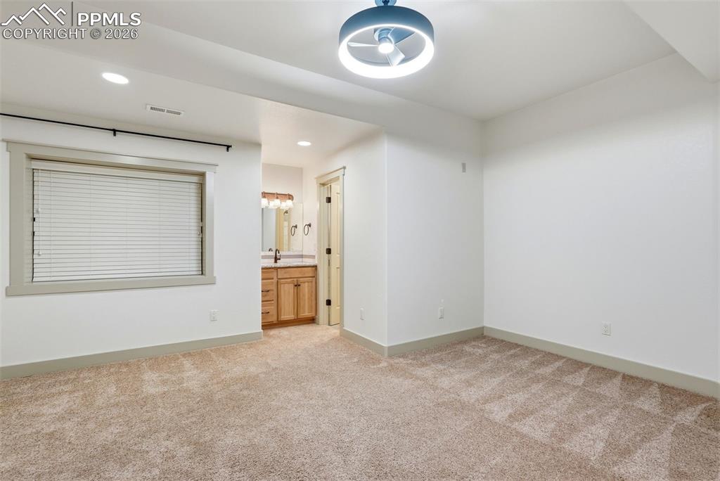 Image 46 of 50: 4th bedroom featuring light colored carpet, recessed lighting, and ensuite 