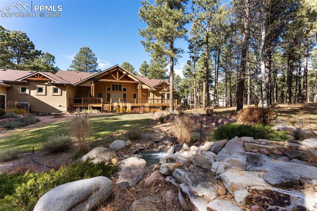 Image 8 of 50: Rear view of the home from the water fall feature.