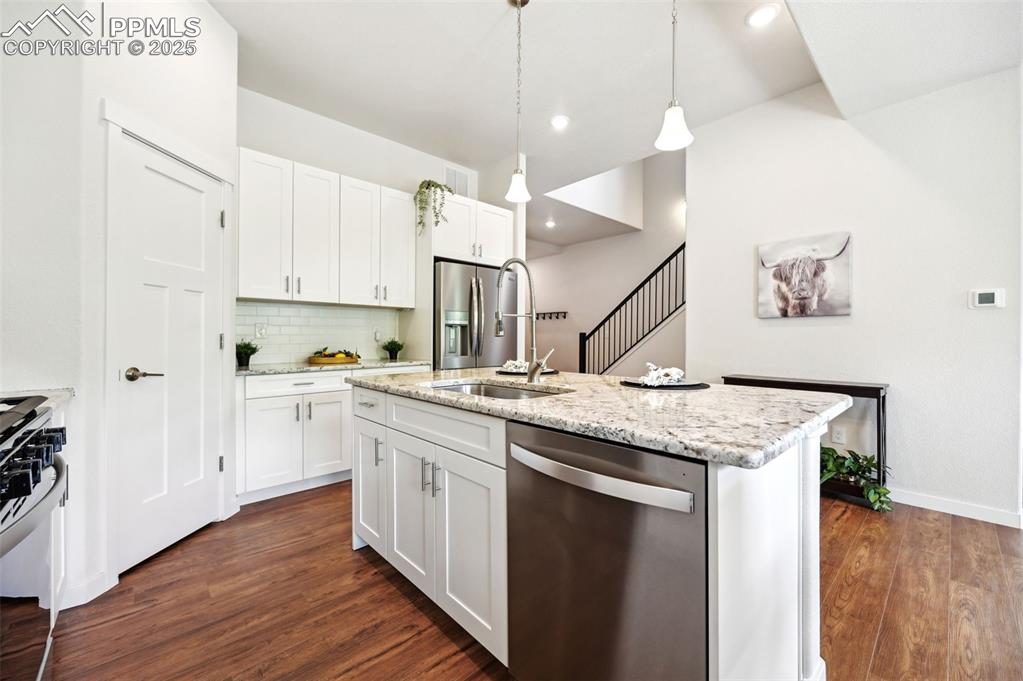 Image 12 of 30: Large Island Kitchen with a counter bar, pantry, and white shaker cabinets 