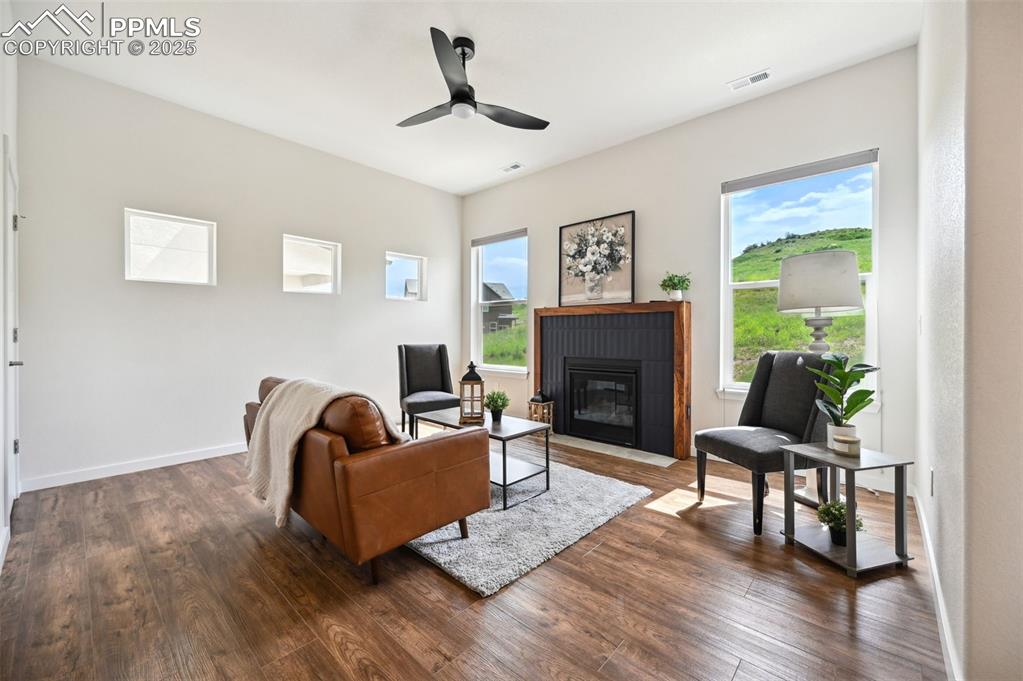 Image 13 of 30: Sun filled Living  Room with lighted ceiling fan and custom gas-log firepla