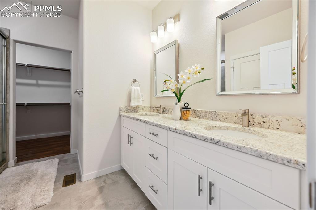 Image 21 of 30: Upper level Primary Spa Shower Bathroom with dual sink vanity and framed mi
