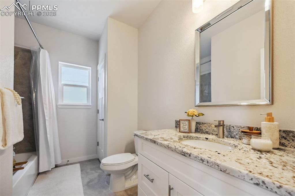Image 27 of 30: Upper Level Full Hall Bathroom with vanity, framed mirror, and tiled tub/sh