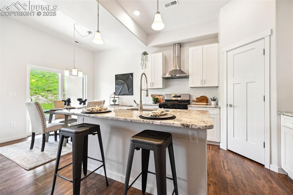 Image 6 of 30: Island Kitchen and Dining Area with slider to covered patio.