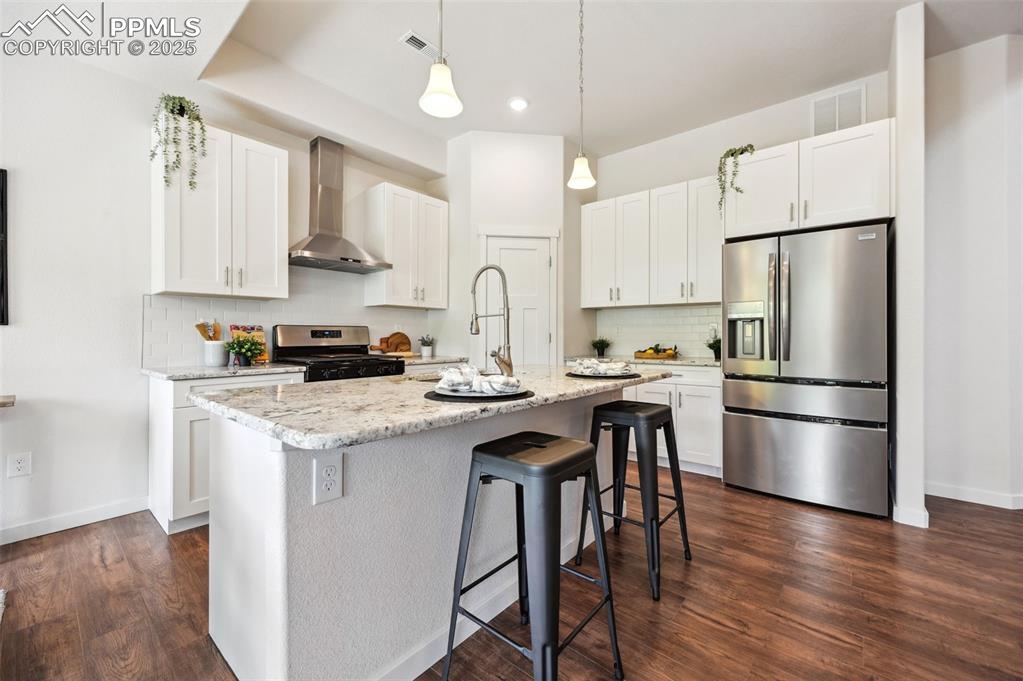 Image 7 of 30: Island Kitchen with white shaker cabinets, quartz countertops, and stainles