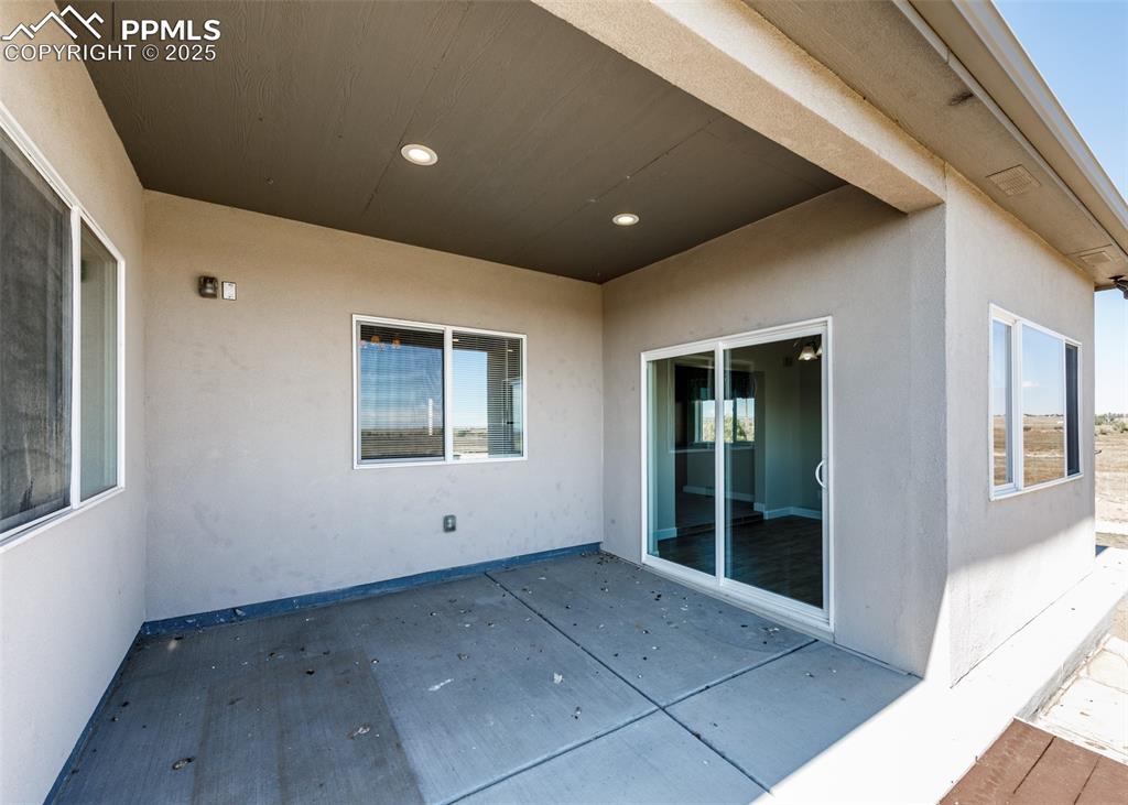 Image 12 of 27: Covered concrete patio.