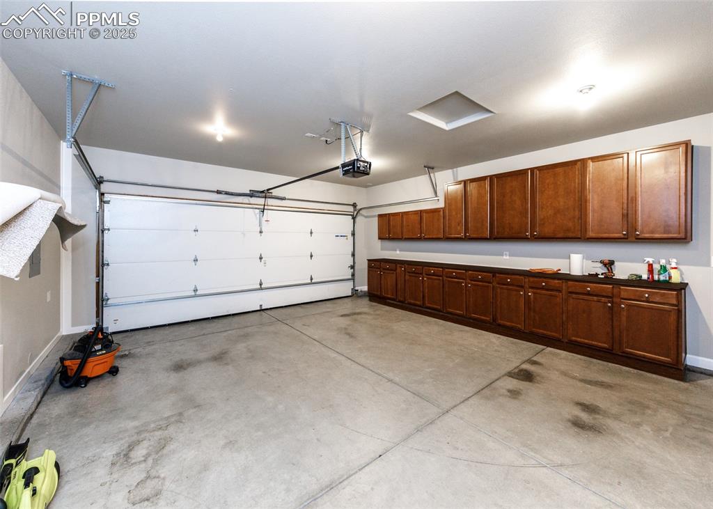 Image 24 of 27: Cabinets galore in the attached garage. Uppers and lowers and countertops.