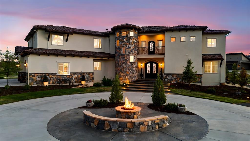 Caption: Front of home with Elegant Tuscan façade Elegant Tuscan exterior with lit entry, fire feature, and c