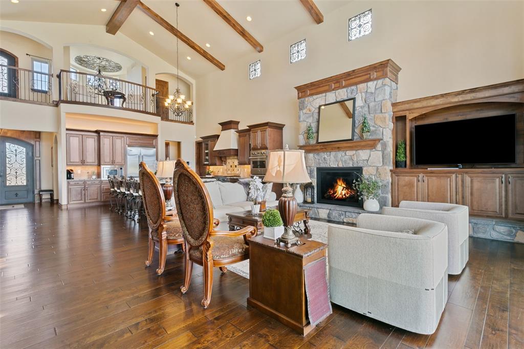 Image 11 of 50: Open two-story living space highlighted by a beamed ceiling and stone heart
