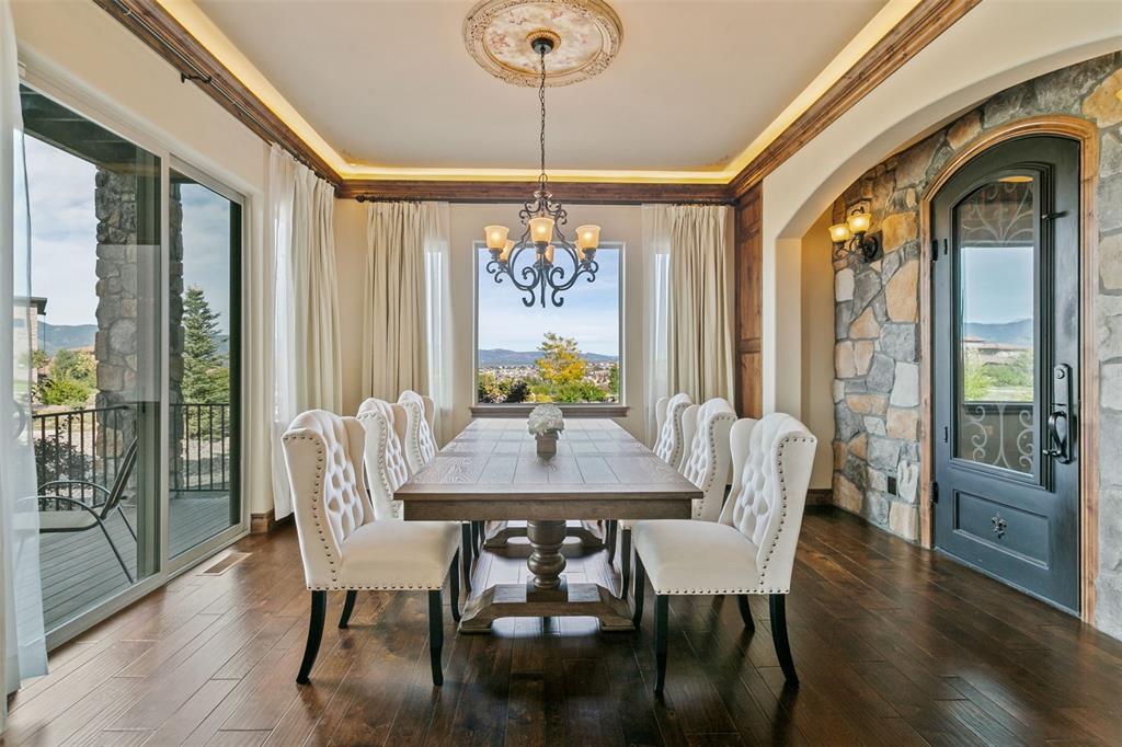 Image 14 of 50: Formal dining room with mountain views, elegant lighting, and private wine 
