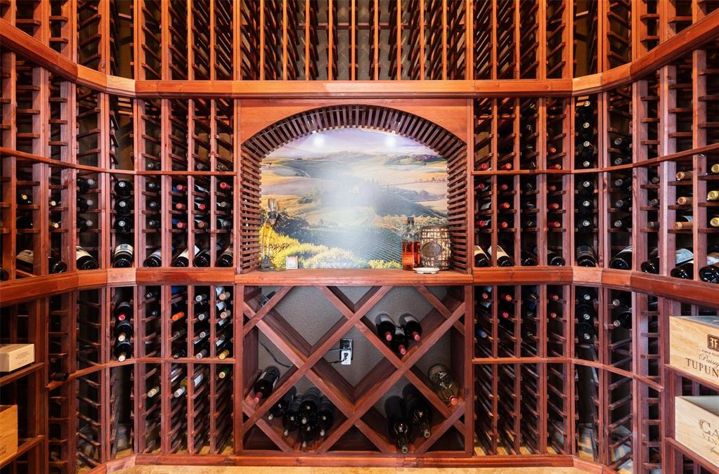 Image 16 of 50: Temperature-controlled wine room with custom wood racking and storage for 1