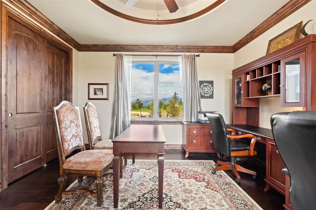 Image 17 of 50: Private office with rich wood finishes and inspiring mountain views