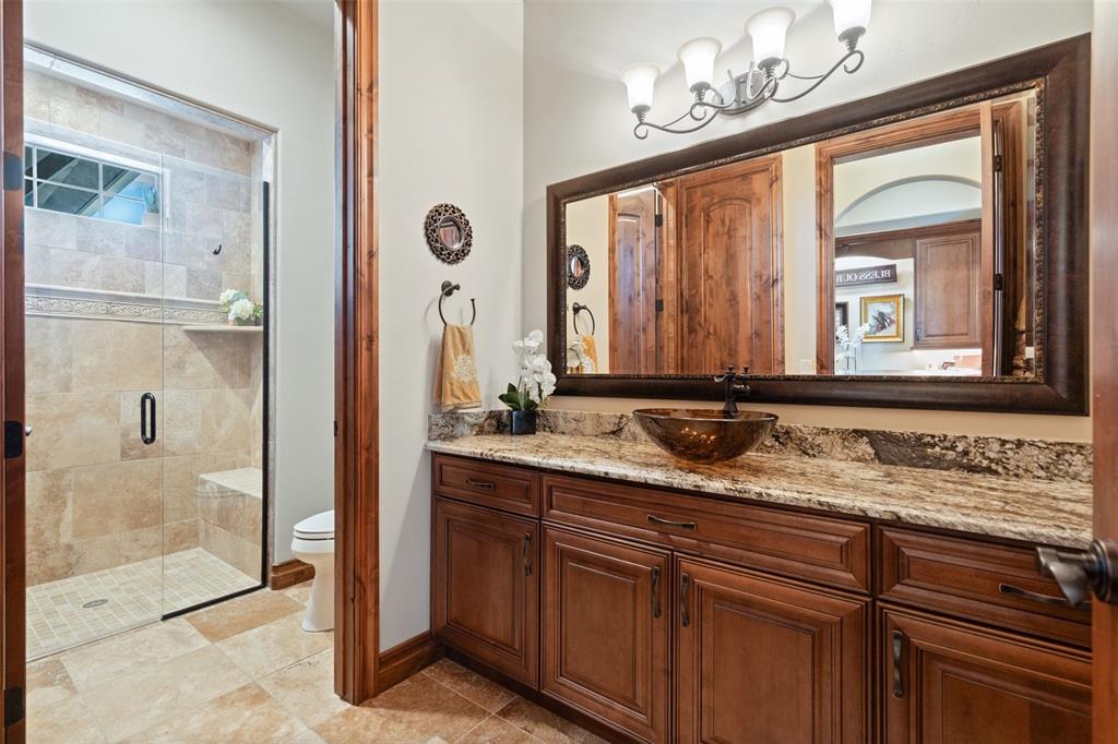 Image 18 of 50: Main-level bath with a granite vanity and walk-in shower, conveniently loca