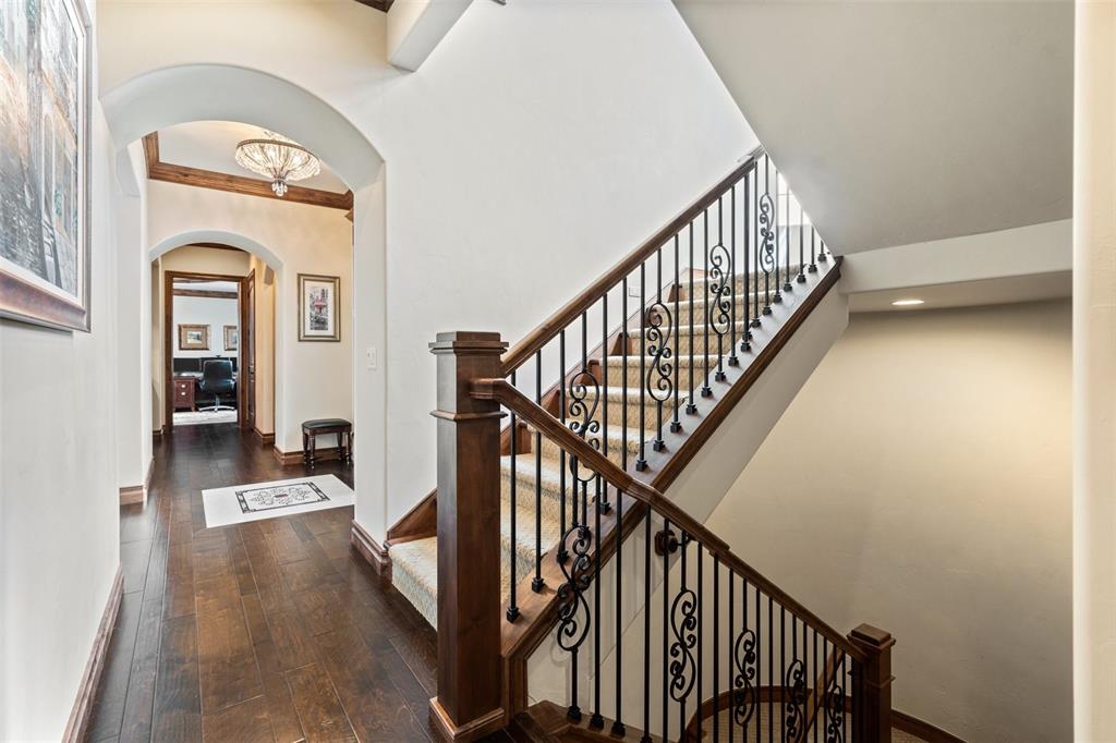 Image 19 of 50: Beautifully detailed hallway showcasing arches, wood trim, and a dual-acces