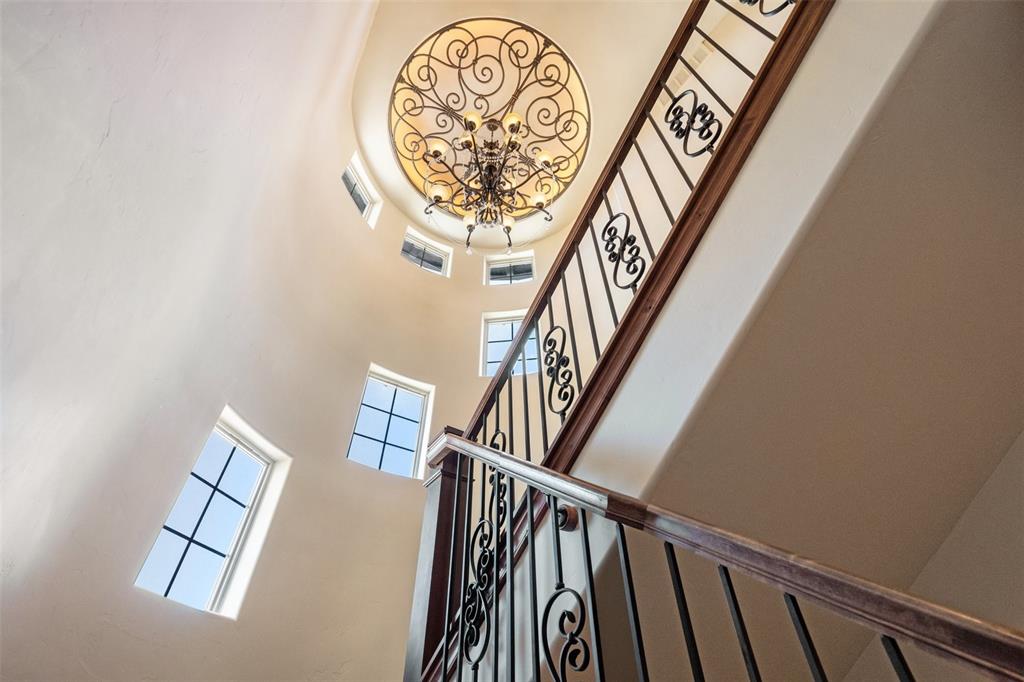Image 20 of 50: Architectural ceiling detail and ironwork add elegance to the staircase