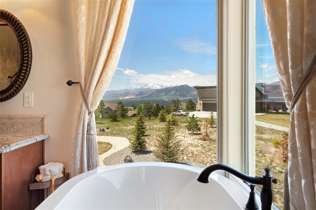 Image 28 of 50: Relaxing freestanding soak tub with a picturesque view of the Front Range