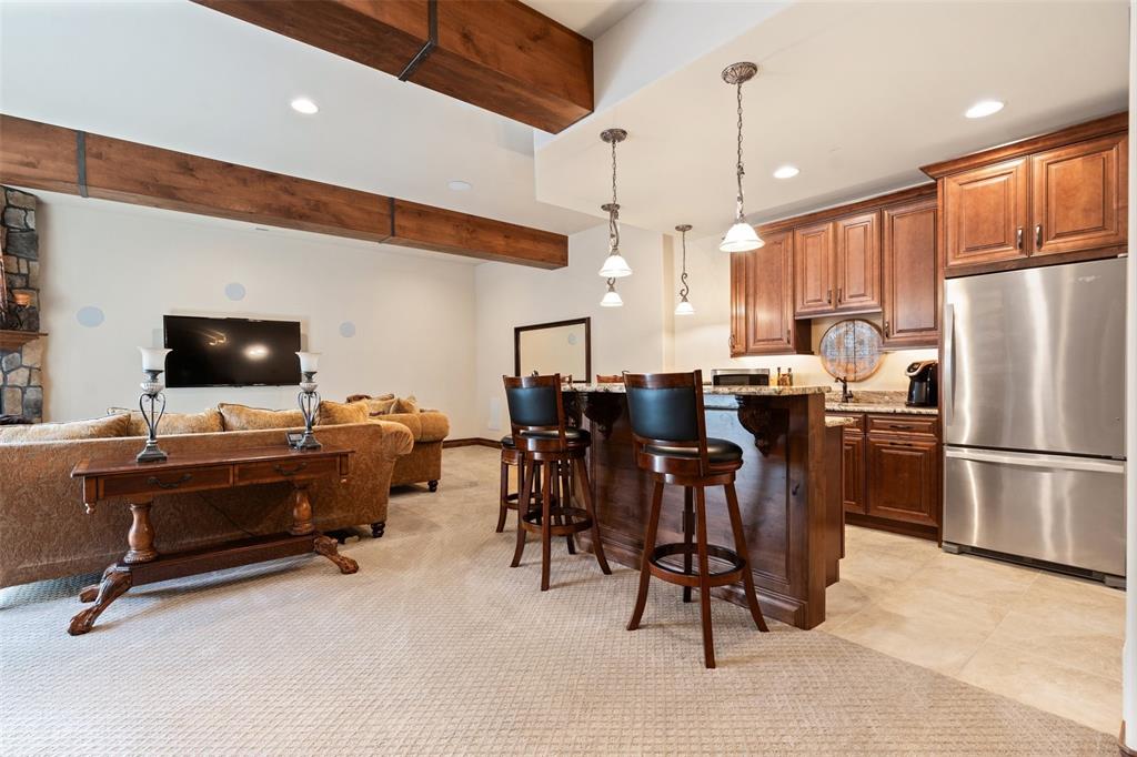Image 35 of 50: Lower-level living space featuring a granite-topped wet bar and inviting me