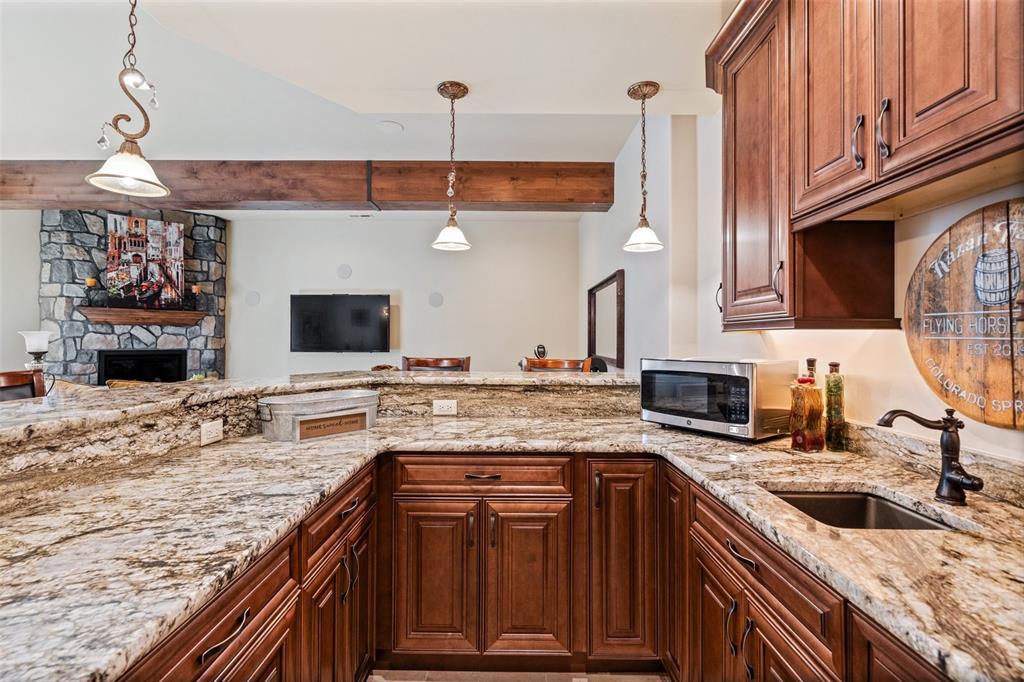 Image 38 of 50: well-appointed wet bar with granite counters and bar seating, perfectly pos