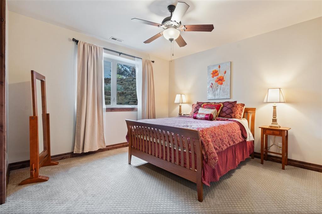 Image 41 of 50: Spacious lower-level bedroom with a window well designed to bring in soft, 