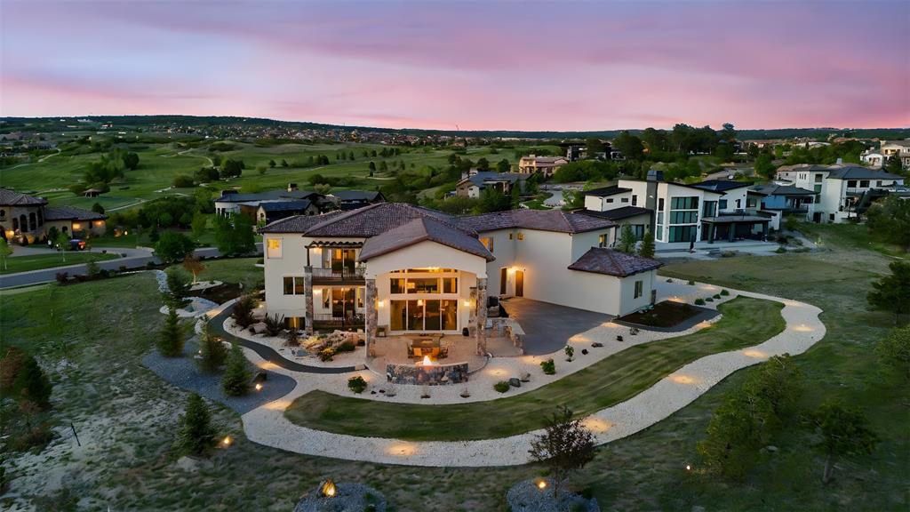Image 47 of 50: Beautiful aerial view highlighting the home’s firepit patio, landscaped pat