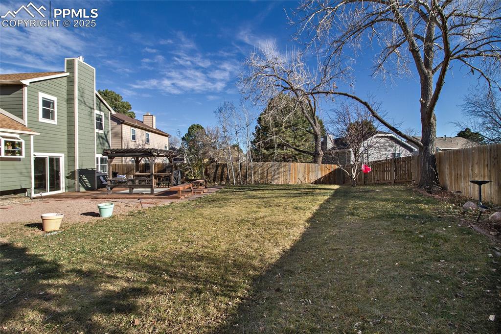 Image 12 of 43: Fenced backyard featuring a deck and a pergola