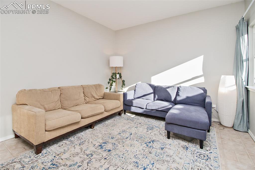 Image 28 of 43: Living area with baseboards and light tile patterned floors