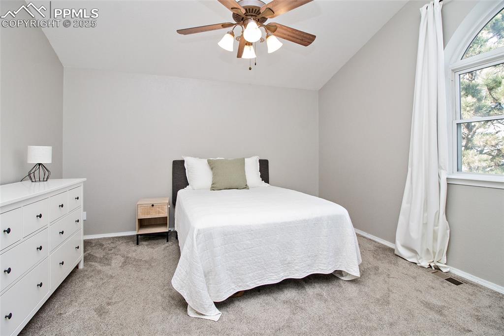Image 35 of 43: Bedroom featuring light carpet, a ceiling fan, and vaulted ceiling