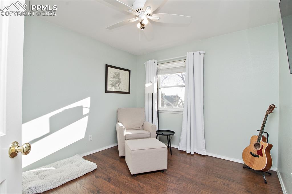 Image 41 of 43: Living area featuring dark wood-style floors and a ceiling fan