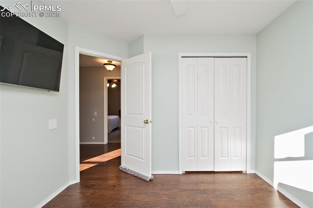 Image 42 of 43: Unfurnished bedroom with dark wood-style floors, a closet, and ceiling fan