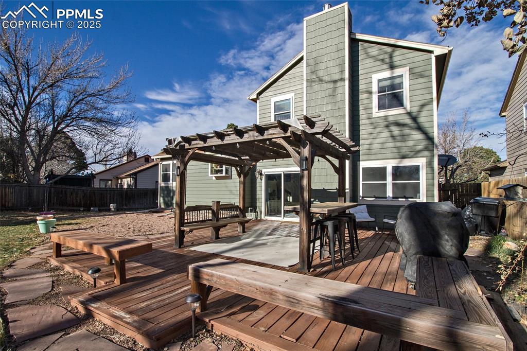 Image 9 of 43: Rear view of property with a fenced backyard, a deck, outdoor dining area, 