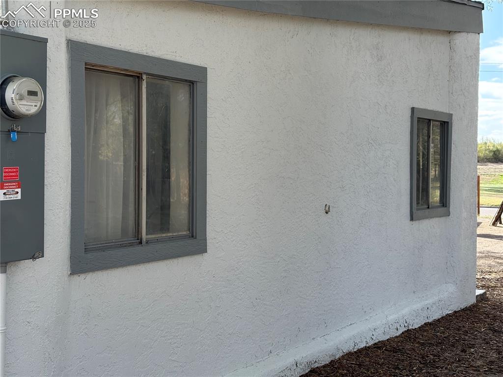 Image 6 of 8: View of side of property with stucco siding