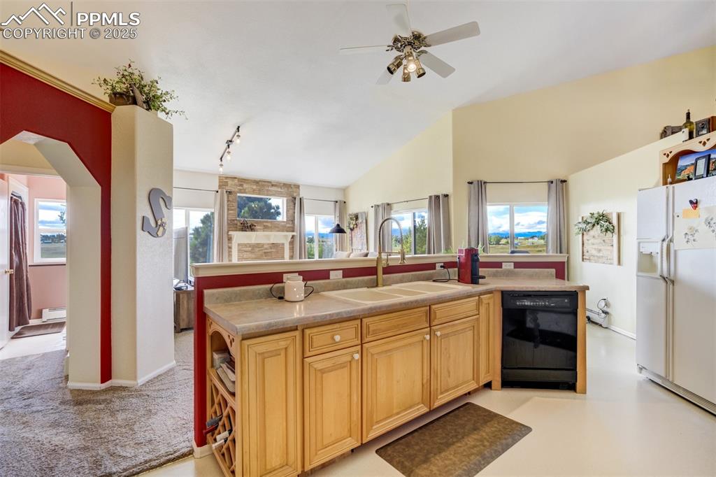 Image 12 of 50: Kitchen featuring white refrigerator with ice dispenser, arched walkways, b
