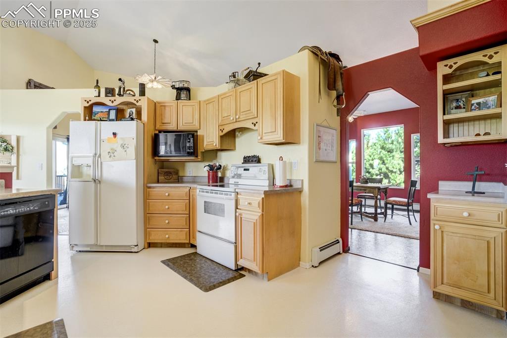 Image 13 of 50: Kitchen with arched walkways, black appliances, finished concrete floors, a