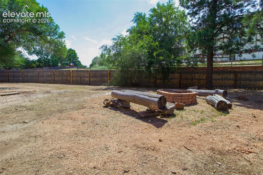Image 22 of 23: Fire pit and mature trees