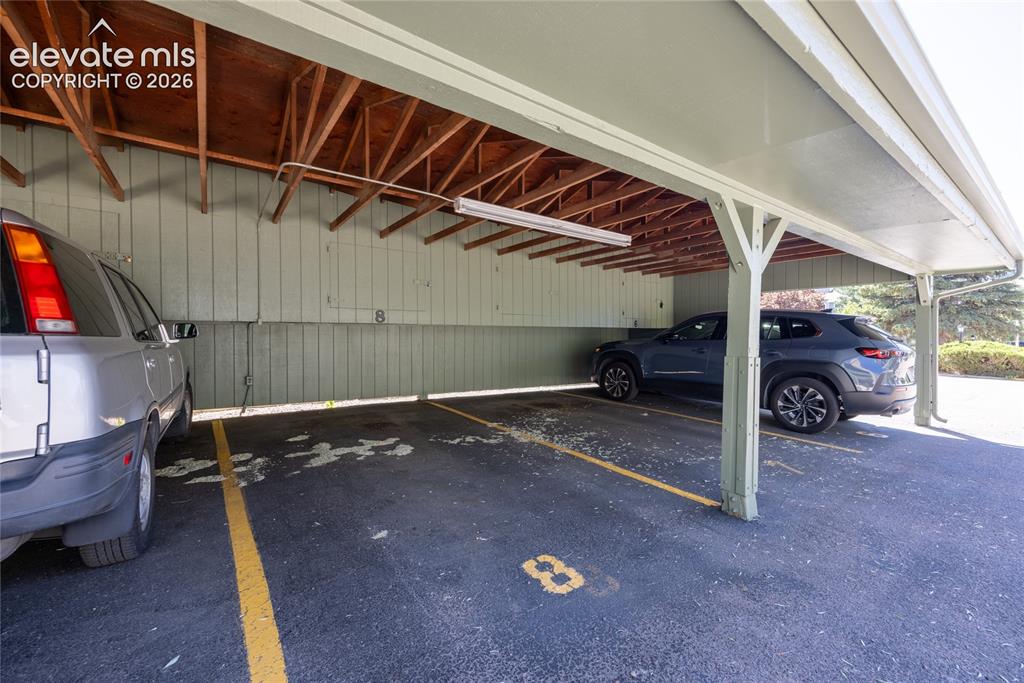 Image 25 of 25: Assigned carport and storage area.