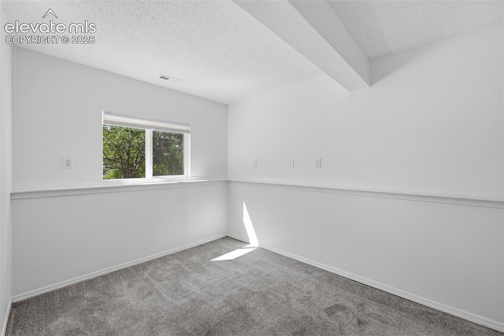 Image 17 of 29: Smaller basement bedroom to the right of the sitting area, garden level bas